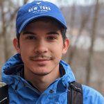 A photo of Douglas in hiking gear walking through a forrest